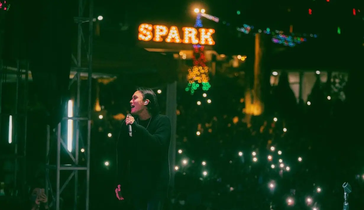 Rizky Febian saat mengajak penonton bernyanyi bersama penonton pada konser Acara Grand Opening SPARK, Samarinda, Sabtu (2/7/2022) malam.  Penyanyi bersuara emas ini sukses membius para penonton yang menyaksikan lewat aksinya menyanyikan lagu di atas panggung. (Instagram/rizkyfbian)