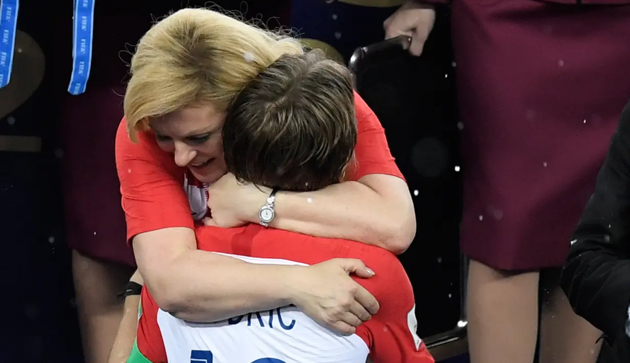 Presiden Kroasia, Kolinda Grabar-Kitarovic menghibur Kapten Kroasia, Luka Modric saat penyerahan medali dan trofi Piala Dunia 2018 di Luzhniki Stadium, Minggu (15/7). Kroasia harus puas menjadi runner-up seusai kalah 2-4 dari Prancis. (AFP/GABRIEL BOUYS)