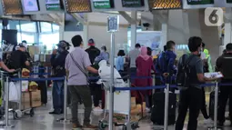 Calon penumpang melakukan check in tiket pesawat di Terminal 3 Bandara Soekarno Hatta, Tangerang, Banten, Jumat (18/12/2020). PT Angkasa Pura II (Persero) atau AP II memprediksi lalu lintas sebanyak 2,1 juta penumpang pada periode angkutan Natal dan Tahun Baru 2021. (Liputan6.com/Angga Yuniar)
