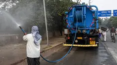 Petugas menyemprotkan air ke pohon-pohon di pinggir jalan New Delhi, India, Rabu (6/11/2019). Hal tersebut dilakukan dalam upaya untuk mengurangi polusi udara dengan memerangi akumulasi debu. (Photo by Prakash SINGH / AFP)