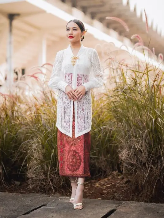 Prilly Latuconsina tampil apik dengan kebaya putih lengan panjang brokat dipadukan dengan kain batik warna merah. Ditambah aksesori bros keemasan senada dengan anting-antingnya. [@prillylatuconsina96]