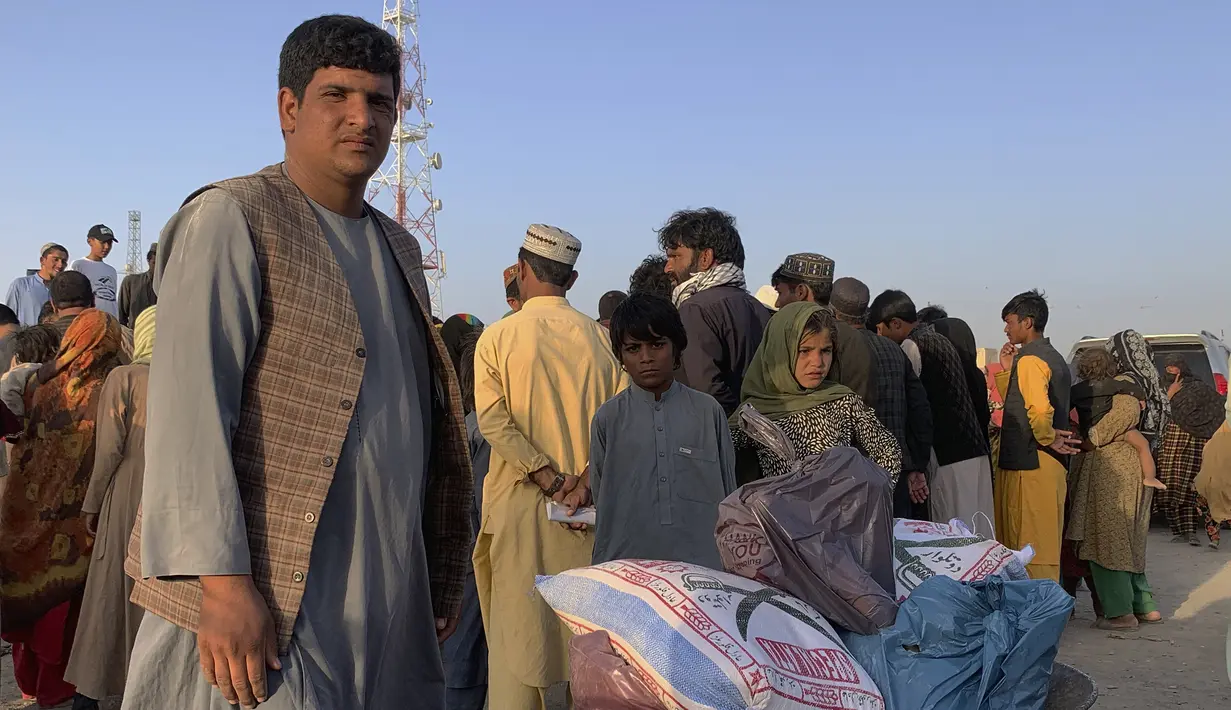 Seorang pria Afghanistan bersiap untuk mendorong gerobak dorong dengan barang-barang makanan yang didistribusikan oleh organisasi Kristen yang berbasis di Islamabad di pinggiran Chaman, sebuah kota perbatasan di provinsi Baluchistan barat daya Pakistan, Selasa (31/8/2021). (AP Photo)