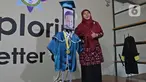 Kepala Sekolah berfoto dengan roboda (robot wisuda) saat wisuda virtual siswa Kelompok Bermain Taman Kanak-kanak (KB TK) Sekolah Nasional Satu di Bekasi, Rabu (1/07/2020). Sekolah menggunakan teknologi virtual dan roboda guna memudahkan prosesi wisuda selama Covid-19.(Liputan6.com/Herman Zakharia)