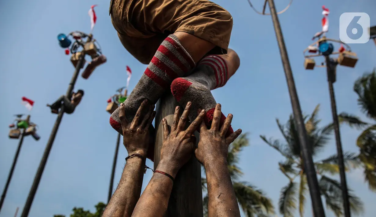 Peserta lomba, yang biasanya berkelompok, harus bekerja sama untuk memanjat pohon pinang dan meraih hadiah-hadiah tersebut. (Liputan6.com/Angga Yuniar)