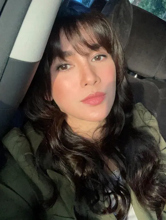 Dari potret ini, apakah terlihat bahwa Ussy adalah seorang ibu dari 4 orang anak? Tak kalah memesona, potret selfienya di dalam mobil dengan cahaya matahari yang semakin menonjolkan kecantikan alami Ussy, walau ia hanya mengenakan riasan wajah natural bernuansa merah muda yang hangat dan sesuai dengan tone kulitnya yang putih. Foto: Instagram.