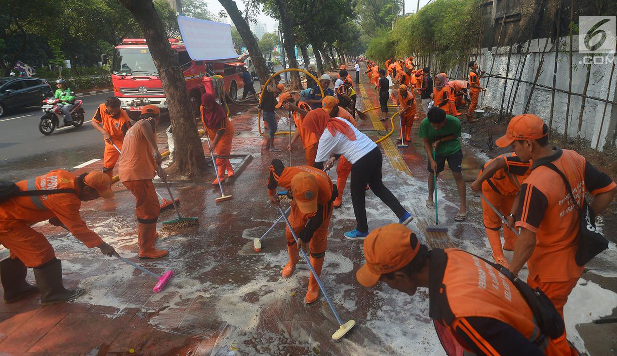 Petugas PPSU membersihkan trotoar di Jalan Asia Afrika, Jakarta, Kamis (2/8). Trotoar yang di pakai para pedagang kaki lima ini di bersihkan guna jelang Asian Games 2018 di Jakarta dan Palembang. (Merdeka.com/Imam Buhori)