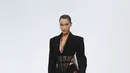 Model Bella Hadid mengenakan membawakan koleksi Spring 2020 dari Mugler dalam gelaran Paris Fashion Week, Rabu (25/9/2019). Bella Hadid  memadukan lingerie hitam transparannya dengan crop blazer berwarna senada. (Christophe ARCHAMBAULT / AFP)