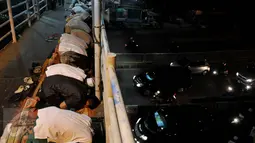 Suasana ibadah Salat Tarawih pertama di kawasan Pasar Gembrong, Jakarta, Rabu (17/6/2015). Terbatasnya jumlah daya tampung musholla membuat warga terpaksa salat di jembatan. (Liputan6.com/Johan Tallo)