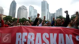 Ratusan buruh mengangkat tangan saat aksi di lapangan DitSabhara Polda Metro Jaya, Jakarta, Rabu (17/2/2016). Dalam aksinya, mereka meminta pencabutan status tersangka pada 26 orang buruh aktivis. (Liputan6.com/Helmi Fithriansyah)