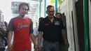 Tio datang bersama tahanan lain saat memasuki kantor pengadilan. Bintang film Filosofi Kopi 2: Ben & Jody itu datang mengenakan kaos polo shirt warna hitam. (Nurwahyunan/Bintang.com)