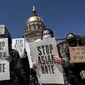 Orang-orang memegang poster saat unjuk rasa "Stop Asian Hate" di luar Gedung Kongres Georgia di Atlanta, Sabtu (20/3/2021). Ratusan demonstran berkumpul mendukung komunitas Asia-Amerika setelah penembakan tempat spa yang menewaskan 8 orang, termasuk di antaranya 6 wanita Asia. (AP Photo/Ben Gray)