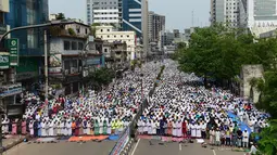 Massa dari kelompok Islam membanjiri jalan di Dhaka, Banglades, Jumat (21/4). Massa menuntut pemerintah untuk menghancurkan sebuah patung di depan Mahkamah Agung karena dianggap sebagai berhala. (AFP PHOTO / STR)