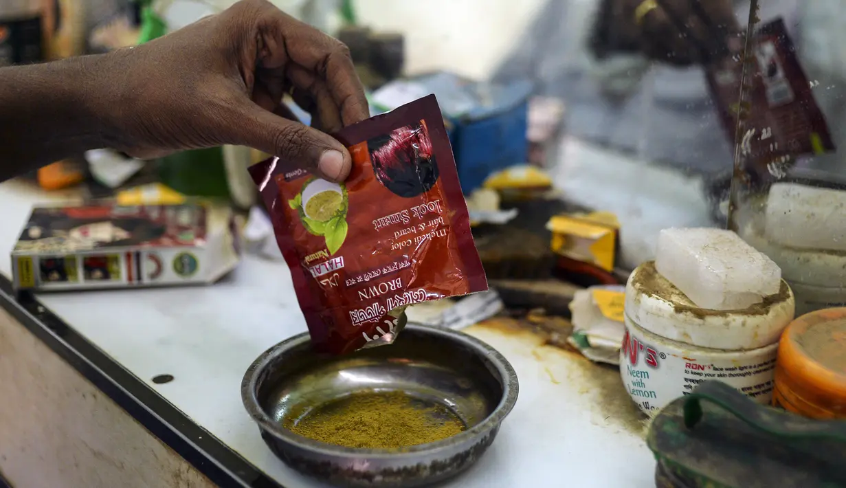 Dalam gambar yang diambil pada 19 Januari 2019, tukang cukur Mohammad Shadat Hossain menyiapkan bubuk pacar (henna) untuk diterapkan ke rambut pelanggannya di Dhaka. Pria tua Bangladesh yang ingin tetap merasa muda, menggunakan berbagai pilihan pacar (henna) yang tersedia. (MUNIR UZ ZAMAN / AFP)