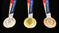 Medali Olimpiade Tokyo 2020 resmi diumumkan kepada publik saat seremoni untuk merayakan momen satu tahun jelang Olimpiade di Tokyo, Rabu (24/7/2019). Medali yang didesain Junichi Kawanishi itu berdiameter 85 mm dan dihiasi gambar dewi Yunani, Nike serta logo Olimpiade. (Behrouz MEHRI/AFP)