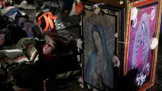 Seorang peziarah beristirahat di samping gambar Bunda dari Guadalupe di kawasan Basilika Guadalupe di Mexico City, Meksiko (11/12). Bunda dari Guadalupe dikenal juga dengan sebutan Our Lady of Guadalupe atau Virgin of Guadalupe. (Reuters/Henry Romero)