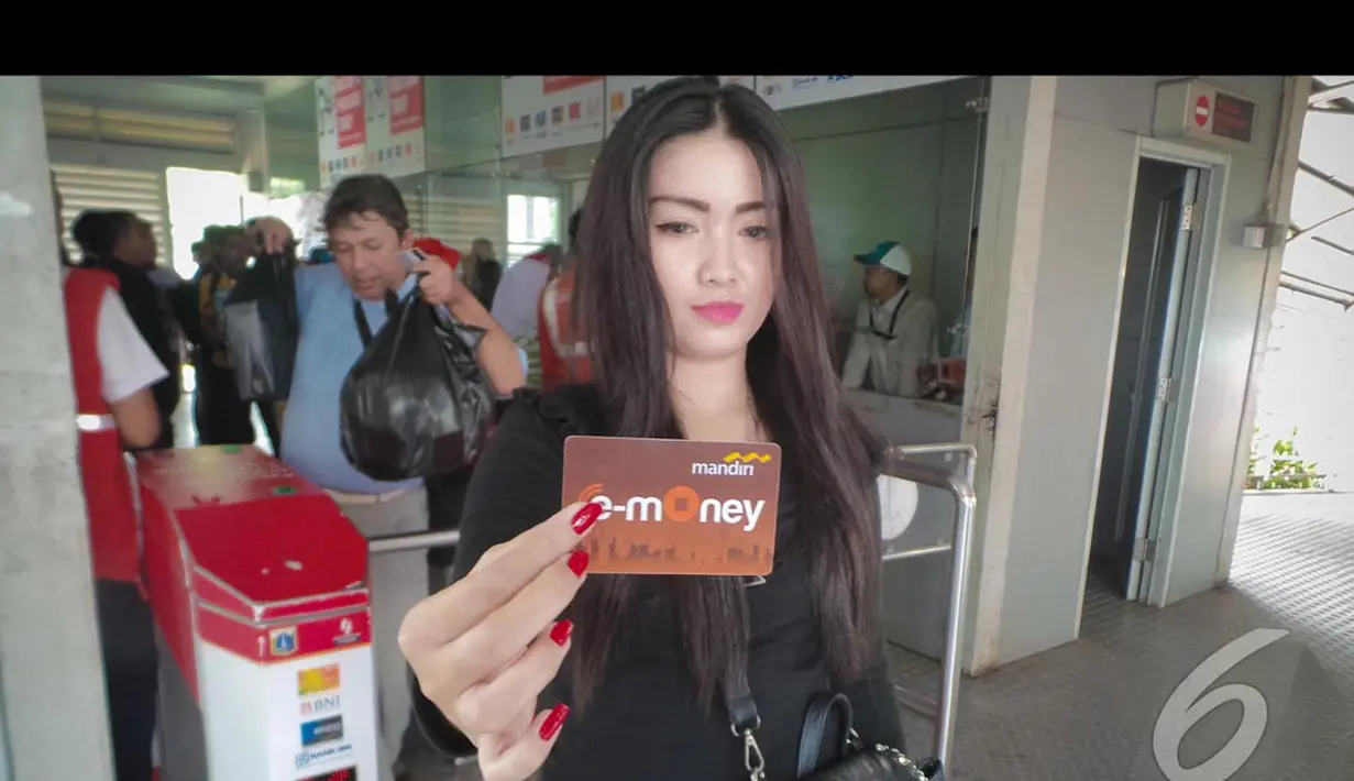 Seorang penumpang cantik memperlihatkan e-ticket yang baru saja dibelinya di halte busway Blok M, Jakarta, Senin (11/8/2014)(Liputan6.com/Faizal Fanani)