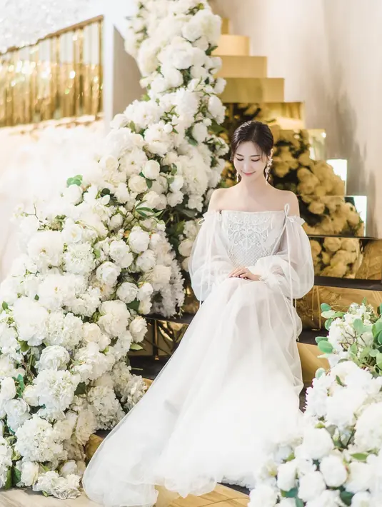 Ia juga membagikan deretan pemotretan yang dilakukannya dalam balutan busana pengantin. Seperti potret ini, ia terlihat secantik bidadari dibalut off shoulder dress berwarna putih. [@yukyung_922]