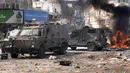 Asap dari api memenuhi udara saat warga Palestina bentrok dengan pasukan Israel di Kota Nablus, Tepi Barat, 22 Februari 2023. Tentara memblokir semua pintu masuk ke kota sebelum mengelilingi sebuah rumah dengan dua pejuang Palestina yang dicari, Hossam Isleem dan Mohammad Abdulghani, di mana keduanya tewas. (AP Photo/Majdi Mohammed)