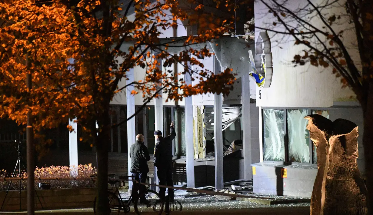 Petugas mengecek kantor polisi setelah ledakan dahsyat di pintu masuk utama di Helsingborg, Swedia (18/10). Ledakan terjadi tengah malam waktu setempat dan juga menghancurkan jendela sebuah bangunan. (AFP Photo/TT News Agency /Johan Nilsson/Sweden Out)