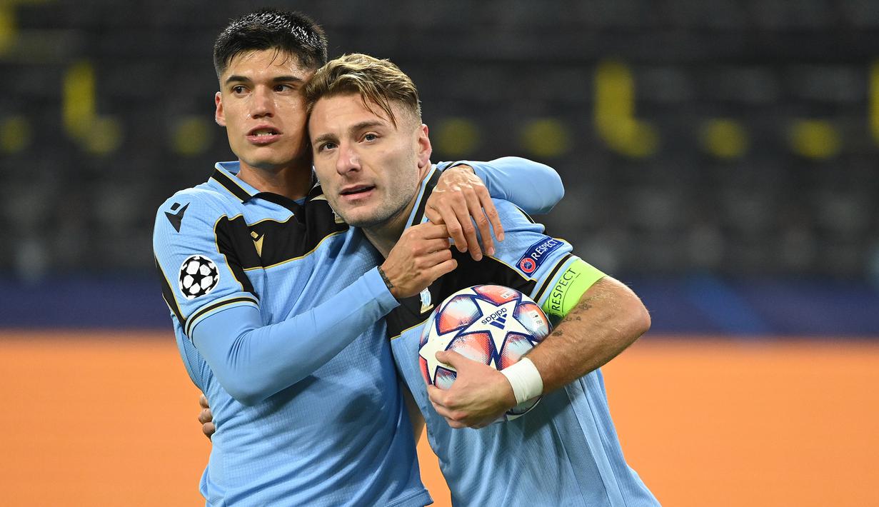 Striker Lazio, Ciro Immobile (kanan), melakukan selebrasi usai mencetak gol ke gawang Borussia Dortmund dalam laga lanjutan Liga Champions 2020/21 Grup F di Signal Iduna Park Stadium, Dortmund, Rabu (2/12/2020) waktu setempat. Lazio bermain imbang 1-1 dengan Dortmund. (AFP/Ina Fassbender)