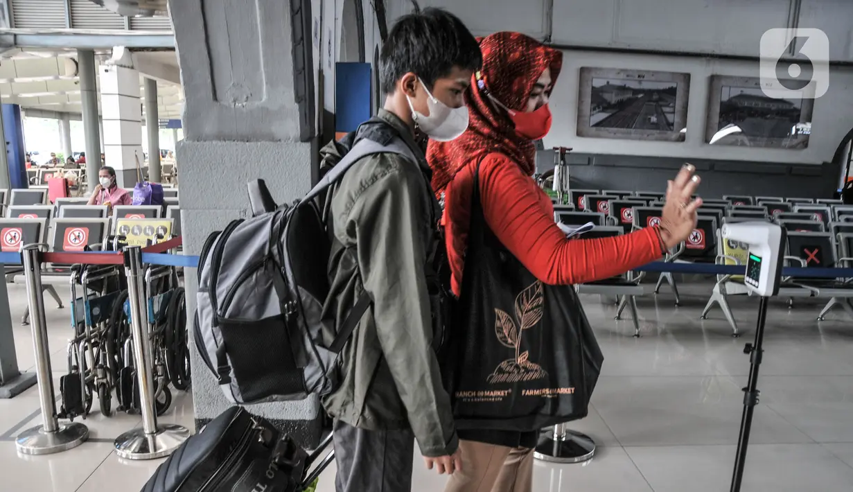 Calon penumpang saat mengecek suhu tubuh di Stasiun Pasar Senen, Jakarta, Senin (20/12/2021). Untuk diketahui, data per Senin (20/12) KAI Daop 1 mencatat jumlah penumpang keberangkatan di Stasiun Pasar Senen mencapai 4.589 orang. (merdeka.com/Iqbal S. Nugroho)