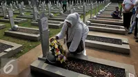 Seorang warga memberikan karangan bunga saat ziarah di TMP Kalibata, Jakarta, Minggu (1/11/2015). Mereka akan membongkar makam keluarga mereka di TMP jika pemerintah melakukan penggusuran terhadap rumah mereka. (Liputan6.com/Johan Tallo)