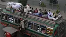 Warga berada di bus saat mereka melakukan perjalanan ke kampung halaman mereka menjelang perayaan Idul Fitri di Lahore (7/5/2021). Lebaran Idul Fitri jatuh pada 13 Mei 2021. (AFP Photo/Arif Ali)