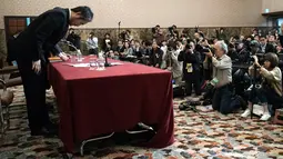 Jumpei Yasuda, jurnalis lepas Jepang yang sempat ditahan 3 tahun di Suriah, membungkuk meminta maaf saat konferensi pers di Tokyo, Jumat (2/11). Yasuda mengaku sepenuhnya bertanggung jawab atas tindakannya selama disandera Suriah. (AP/Eugene Hoshiko)