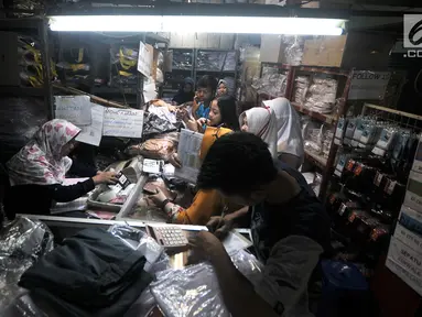 Pedagang melayani calon pembeli seragam sekolah saat berbelanja di salah satu toko di Pasar Sunan Giri, Jakarta, Selasa (3/7). Orangtua murid mulai berburu seragam sekolah untuk anak mereka jelang tahun ajaran baru 2018/2019. (Merdeka.com/Iqbal Nugroho)
