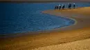 Peserta memacu kudanya saling balap di tepi pantai saat mengikuti lomba pacuan kuda pantai tahunan di Sanlucar de Barrameda, dekat Cadiz, Spanyol (17/8). Pacuan pertama digelar tahun 1845. (AFP Photo/Cristina Quicler)
