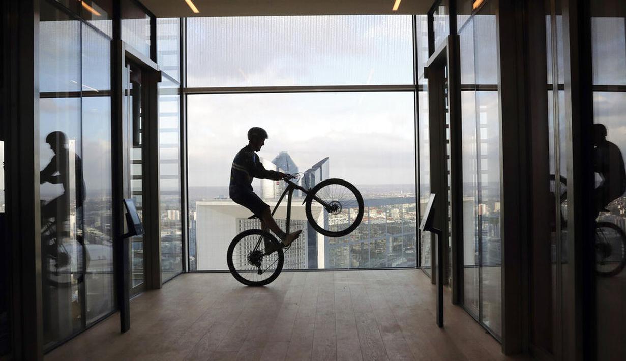 Pembalap sepeda asal Prancis, Aurelien Fontenoy, saat mendaki 768 anak tangga dari 33 lantai gedung Trinity Tower di distrik La Defense, Paris, (17/1/2021). (AP/Christophe Ena)