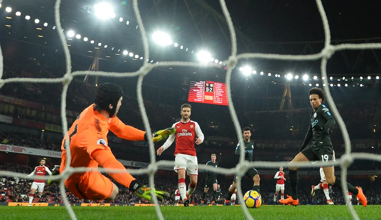 Gelandang Manchester City Leroy Sane menendang bola ke gawang Arsenal pada laga pekan ke-28 Premier League di Emirates Stadium,  Jumat (2/3). Manchester City menang telak tiga gol tanpa balas atas Arsenal. (Glyn KIRK/AFP)