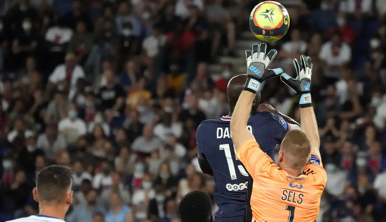 Kiper Strasbourg Matz Sels melakukan penyelamatan di depan gelandang Paris Saint-Germain (PSG) Danilo Pereira pada laga pekan kedua Liga Prancis di Stadion Parc des Princes, Minggu (15/8/2021) dini hari WIB. PSG membekuk tamunya Strasbourg dengan skor 4-2. (AP Photo/Francois Mori)