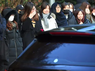 Kesedihan para fans saat mobil yang membawa jenazah Jonghyun SHINee keluar dari rumah persemayaman di Asan Hospital, Seoul menuju tempat pemakaman, Kamis (21/12). Lebih dari 300 fans berkumpul saat peti mati Jonghyun mulai dihantarkan. (JUNG Yeon-Je/AFP)