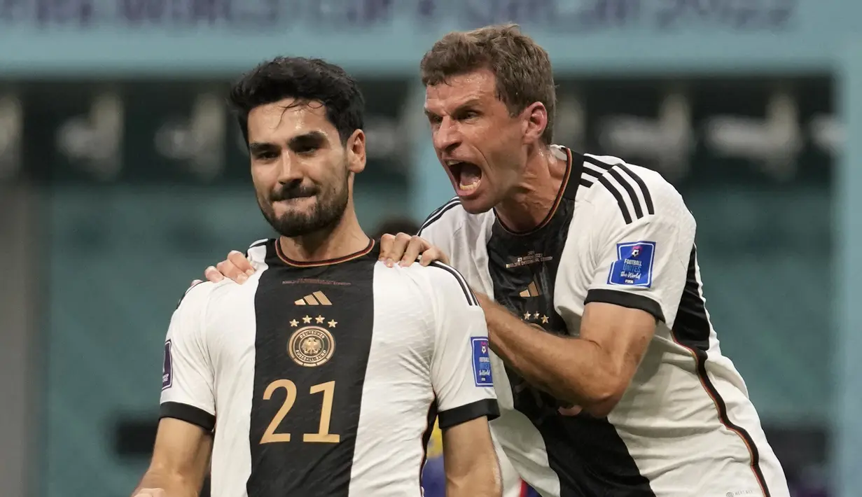 Gelandang Jerman, Ilkay Gundogan (kiri) berselebrasi dengan rekan setimnya Thomas Mueller setelah mencetak gol pembuka timnya ke gawang Jepang selama pertandingan grup E Piala Dunia 2022 Qatar di Stadion Internasional Khalifa di Doha, Qatar, Rabu (23/11/2022). Jepang menang tipis atas Jerman dengan skor 2-1. (AP Photo/Luca Bruno)