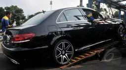 Petugas menurunkan Mercy E - 400 di Kawasan Senayan, Jakarta, Kamis (16/4/2015). Sebanyak 42 mobil disiapkan Pemerintah untuk membawa Kepala Negara dalam rangkaian acara KAA ke-60 di Kota Jakarta dan Bandung. (Liputan6.com/Johan Tallo)