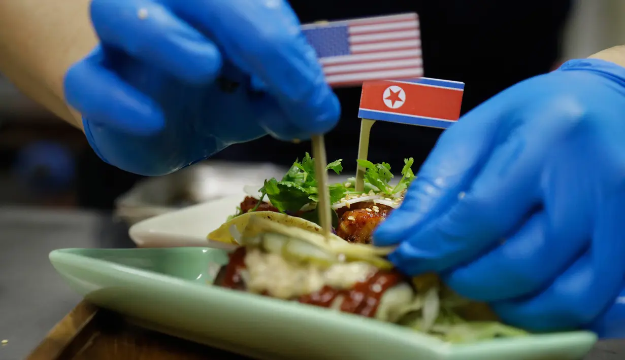 Seorang koki menghias makanan taco bernama El Trumpo dan Rocket Man di sebuah restoran di Singapura, 7 Juni 2018. Makanan itu memanfaatkan momentum pertemuan Donald Trump dan Pemimpin Korea Utara Kim Jong-un di Singapura 12 Juni nanti. (AP/Wong Maye-E)