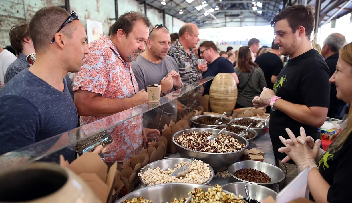 Pengunjung bertanya tentang makanan berbahan dasar serangga yang dijajakan di salah satu kios di Sydney, Australia, Sabtu (28/4). Suku asli di Australia telah mengonsumsi serangga sebagai sumber protein hewani. (AFP FOTO / ANDREW MURRAY )