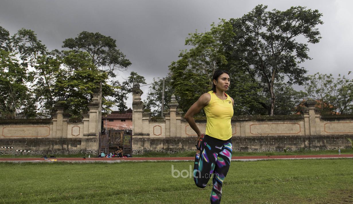 Atlet atletik Indonesia, Maria Londa, melakukan pemanasan sebelum latihan jelang SEA Games 2017 di Lapangan umum Mengwi, Bali, Minggu (10/7/2017). (Bola.com/Vitalis Yogi Trisna)