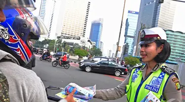 Petugas Kepolisian Direktorat Lalu Lintas Polda Metro Jaya bagikan peta mudik gratis, Jakarta, Jumat (18/07/2014)(Liputan6.com/Faizal Fanani)