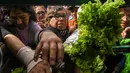 Petani membagikan sayuran secara gratis saat demonstrasi petani di alun-alun Plaza de Mayo dekat Istana Presiden Casa Rosada di Buenos Aires, Senin (24/4). (AFP FOTO / Eitan ABRAMOVICH)
