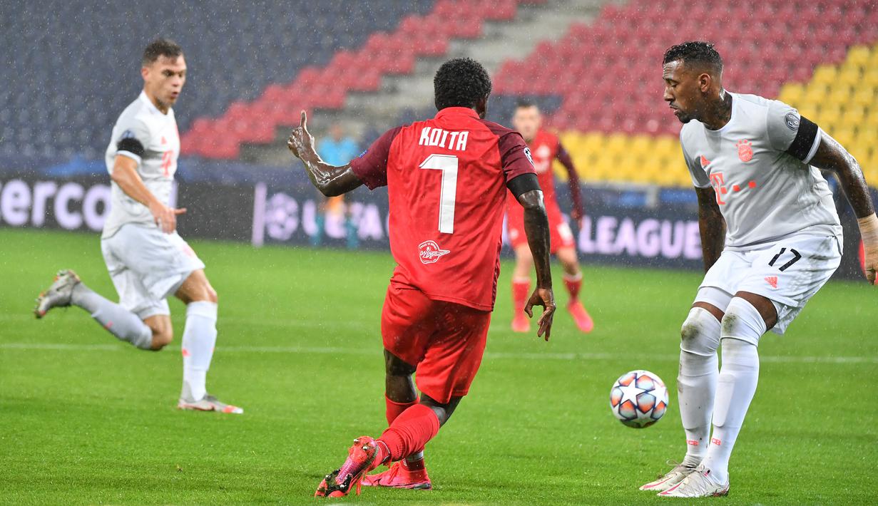 Bek Bayern Munchen, Jerome Boateng, berebut bola dengan penyerang Salzburg, Sekou Koita, pada laga lanjutan Liga Champions 2020/2021 di Stadioin Wals-Siezenheim, Rabu (4/11/2020) dini hari WIB. Bayern Munchen menang 6-2 atas Salzburg. (AFP/Barbara Gindl/APA)