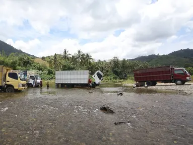 Sejumlah truk dicuci di Sungai Kilo Sembilan, Popayato, Gorontalo, Minggu (11/9). Untuk menghemat biaya, sungai tersebut menjadi lokasi favorit bagi para sopir untuk beristirahat sambil membersihkan kendaraannya. (Liputan6.com/Immanuel Antonius)