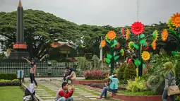 Sejumlah muda-mudi asyik berfoto di Alun-alun Tugu Kota Malang, Rabu (21/1/2015). (Liputan6.com/Faizal Fanani)