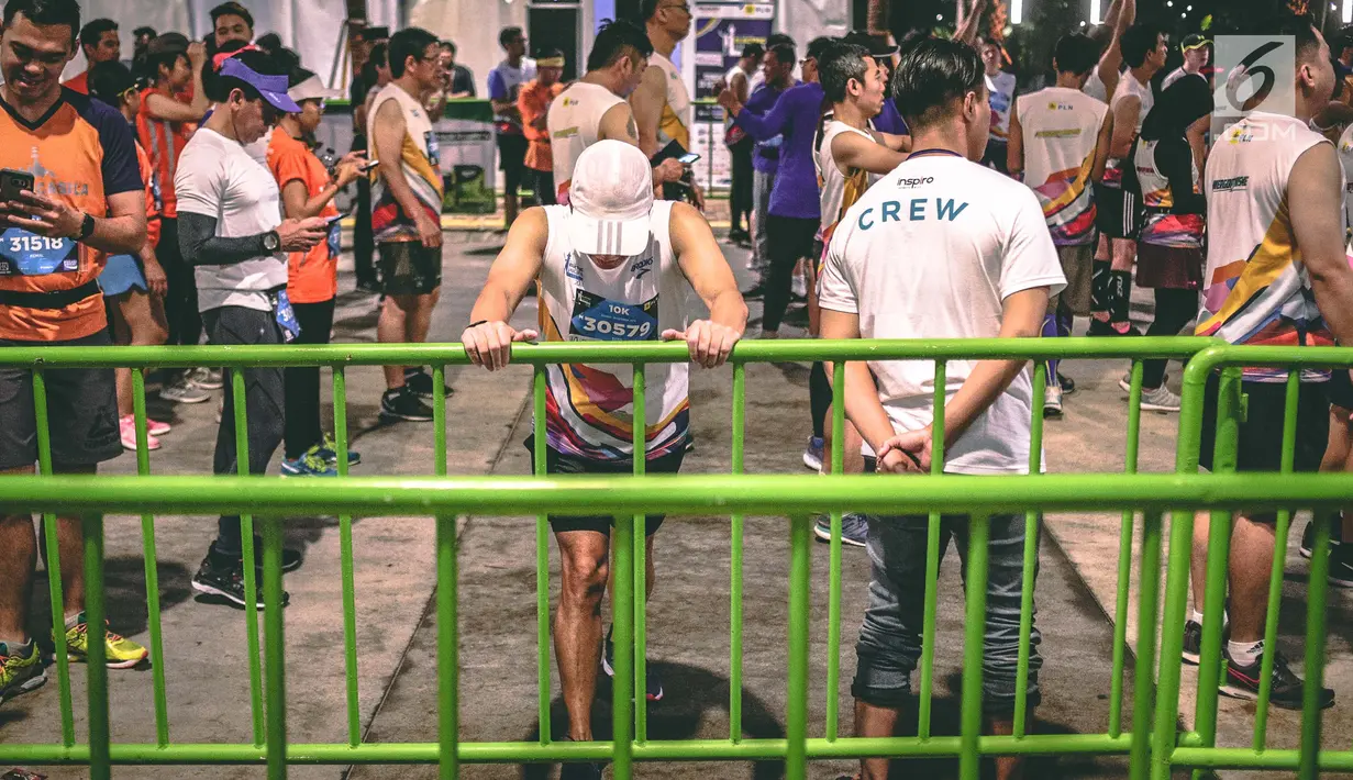 Peserta pemanasan sebelum mengikuti Jakarta Marathon 2018 di Gelora Bung Karno, Jakarta, Minggu (28/10). Sebanyak 12.500 pelari meramaikan Jakarta Marathon 2018, Memasuki tahun keenam, Jakarta Marathon yang di sponsori PLN. (Liputan6.com/Faizal Fanani)