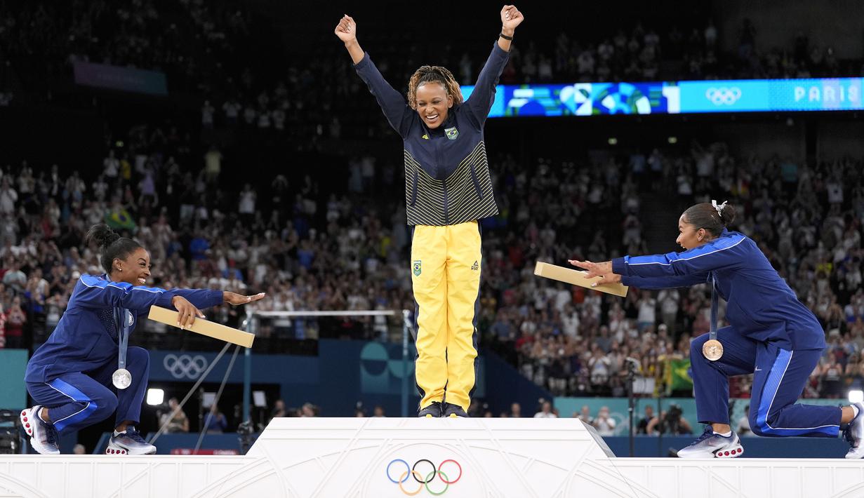Dua pesenam Amerika Serikat, Simone Biles dan Jordan Chiles merayakan kemenangan pesenam Brasil, Rebeca Andrade pada cabang olahraga senam Olimpiade Paris 2024 di Bercy Arena, Paris, Prancis, Senin (05/08/2024). (AP Photo/Abbie Parr)