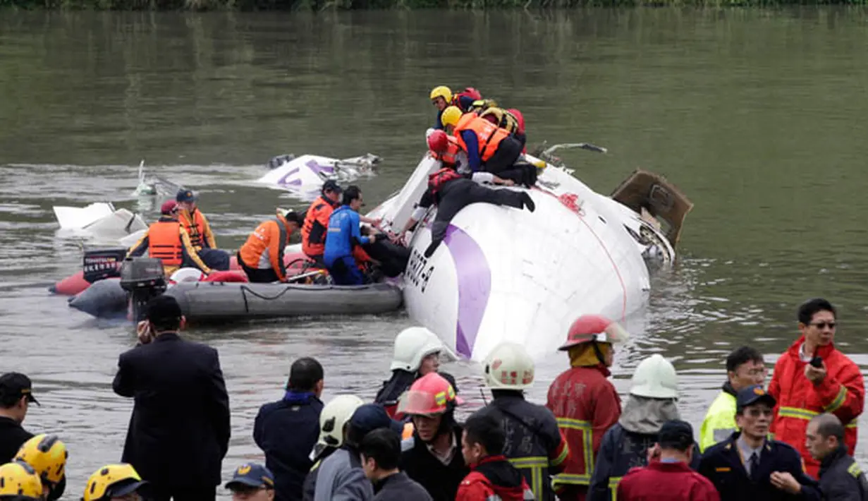 Tim penyelamat mengevakuasi penumpang yang terjebak di badan pesawat yang tenggelam di Sungai Taipei, Taiwan, Rabu (4/2/2015). Pesawat yang mengangkut 58 penumpang dan awak pesawat itu terhempas ke sungai saat hendak lepas landas. (REUTERS/Pichi Chuang)