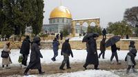 Sekelompok orang Yahudi mengunjungi Temple Mount yang dikenal oleh umat Islam sebagai Noble Sanctuary di Kompleks Masjid Al-Aqsa, Kota Tua Yerusalem, 27 Januari 2022. Hujan salju yang jarang melanda sebagian wilayah Israel dan Tepi Barat telah menutup sekolah dan bisnis. (AP Photo/Mahmoud Illean)