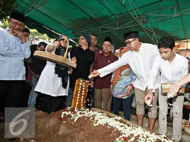 Presenter Farhan bersama keluarga menaburkan bunga di pemakaman anak pertamanya di TPU Tanah Kusir, Jakarta, Senin (21/12). Ridzky menghebuskan nafas terakhirnya di usia 16 tahun pada Minggu, (20/12/2015) pukul 13.40 WIB. (Liputan6.com/Immanuel Antonius)