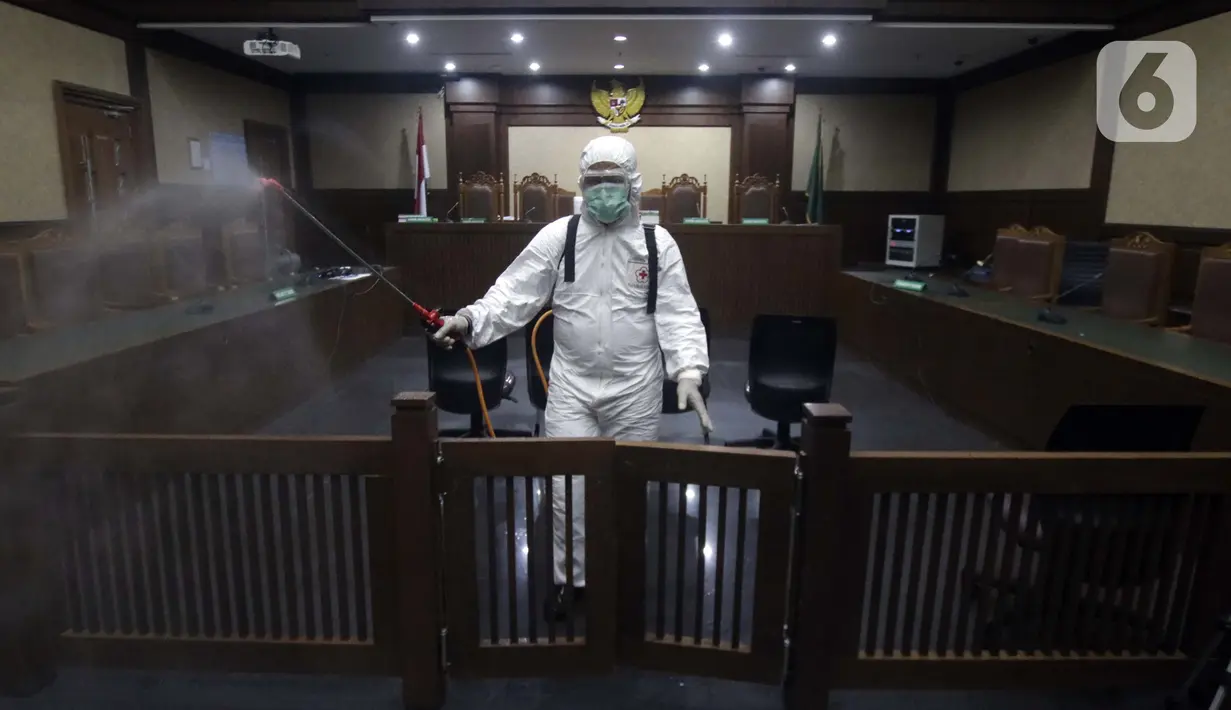 Petugas Palang Merah Indonesia saat melakukan penyemprotan cairan disinfektan di salah satu ruang sidang Pengadilan Negeri Jakarta Pusat, Rabu (18/3/2020). Penyemprotan cairan disinfektan untuk mencegah penyebaran virus corona COVID-19. (Liputan6.com/Helmi Fithriansyah)